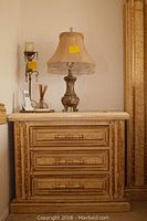 Front view of marble top nightstand with decorative lamp and candle holder