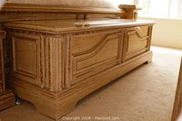 Side view of wooden storage chest showing crackled finish, panel details, and base with feet.