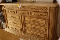 Front view of nine-drawer dresser showing marble top and carved frame