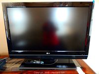 Front view of one 37-inch LG TV showing the full screen and stand with remote on the stand