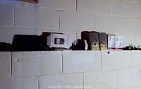 Various small electronics on shelf including Nintendo DS, boxed BlackBerry phones, and other devices