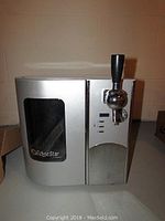 Front view of silver and black beer dispenser with EdgeStar logo, tap handle, and digital control panel.