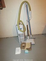 Full setup of the Electrolux Ambassador vacuum with hose, attachments, bags, and manual laid out on floor.