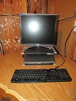 Front view of Dell Latitude D500 laptop with Dell wired keyboard in front and 17-inch Dell monitor on top of the docking station.
