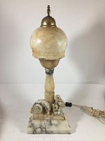 Full front view of lamp showing overall shape, marble base, carved bird motif, and shade