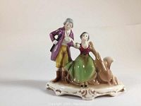 Front view of vintage Goebel porcelain figurine featuring a man, woman and goose on decorative base