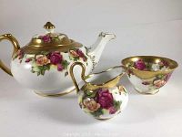 Three-piece set viewed from front showing teapot, creamer and sugar bowl