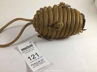 Side view of the coiled gold-tone metal mesh beehive handbag showing strap extending from top