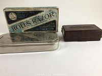 Two antique razors with their original containers; Rolls razor metal case with blue and white printed box and Ever Ready razor in brown Bakelite case.