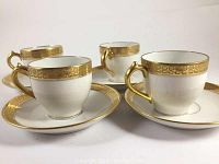 Four Limoges Haviland demitasse cups with matching saucers displayed, showing the full set together.