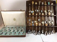 36 souvenir spoons total; 24 on wooden display rack, 12 in green velvet-lined presentation case commemorating Canadian Centennial 1967