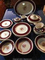 Full set of Crown Ducal china displayed on table showing plates, bowls, cups, saucers, creamer, sugar bowl, serving platter and vegetable server bowl with lids.