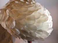 Close-up of white feathers covering the entire hat, showing texture and layering.