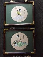 Two framed watercolour paintings displayed one above the other, both with circular compositions of women playing instruments on cream rice paper with green mats and wood and brass frames