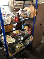 Shelf with various vintage kitchen items including wooden cutting boards, rolling pin, salt and pepper shakers, glass coffee makers, and plastic containers.