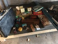 Overview of lot with projection screen, briefcase, pencil sharpener, tape dispenser, board games and various small office and game items.