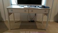 Full front view of the white rectangular table showing the two pull-out drawers and four legs.
