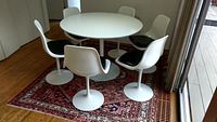 Full view of round table with six pedestal chairs on area rug