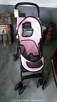 Full view of pink Pet Gear dog stroller with mesh ventilation and black frame profile.