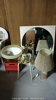 Wide view showing all items including round mirror, table lamp, wall mirrors, and glass dome