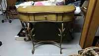 Front view of wooden hallway table showing drawer, curved edges, and decorative metal legs.