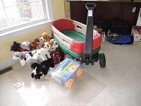 Photo showing the wagon with plush dogs arranged beside it and garden tools in front in a plastic blue container.