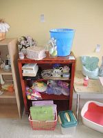 Overall view of wooden shelf holding assorted toys, decor, storage containers, and household items.