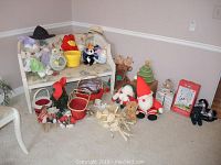 Full view of assorted holiday decor items including baskets, plush toys, Santa, and decorative pieces arranged on floor and bench.