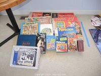 Overview photo showing a collection of vintage board games arranged on a carpeted floor including Perfection and Aggravation along with other classic titles.