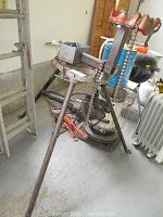 Overall view of Rigid BC 410 pipe bender with tripod legs and chain mechanism, showing used condition.