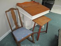 Lift-top captain's desk with brown top and white base, showing the desk with stool and rocking chair beside it.