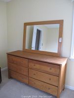 Front angle view of six drawer wooden dresser with attached mirror, showing size and condition.