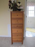 Front view of wooden 6-drawer lingerie chest with round wooden knobs and some knobs missing, stored inside drawers.