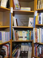 Bookshelves with assorted books including hardbacks and paperbacks, showing vintage to modern varieties.