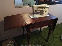 Singer Stylist 513 sewing machine mounted in a wood table with fold out extension, showing general setup and scale.
