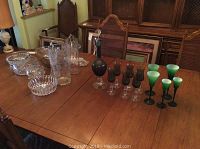 Photo of entire glassware set including bowls, vases, decanter, and glasses on wooden table