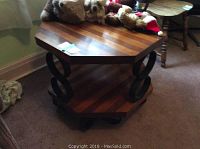 Octagonal wood top end table showing upper surface with wood grain and some items on top
