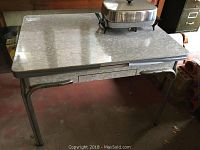 Full view of vintage metal table with electric frying pan on top