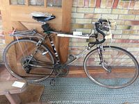 Side view of Schauff 27 inch road bike leaning against wall, showing frame, rear wheel with coaster brake, and rear luggage rack.