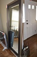 Full view of mirror leaning against wall near entry door