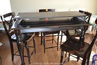 Overview of black pub table with leaf extended and stools around