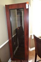 Front view of upright wine cooler showing wood-tone exterior and glass door