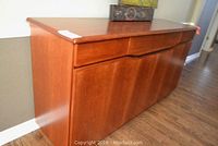 Front view showing two shallow drawers and lower cabinet doors with curved carved handles.