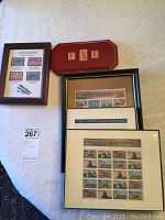 Overview of all five stamp collections including framed and red lacquered board mountings with aviation and train themed stamps in good condition.