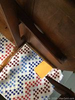 View of the leg and side detail of the large wooden table, showing some wear.