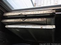 Stack of six wood-framed antique windows with chipping white paint, showing signs of heavy wear and distress, top view.