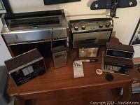 Full group on wooden table showing all electronics, pin, cap and ephemera