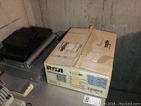Five electronic devices stacked including VCR and DVD players with RCA box and other boxes visible