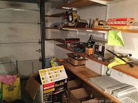 Photo of auto maintenance items on shelves, including shop vac box and various car maintenance supplies.