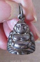 Front close-up view of the vintage sterling silver Buddha pendant showing embossed details and facial features.